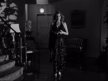 Movie still from “Affair in Trinidad” (1952), directed by Vincent Sherman – A black and white photo of a woman in a dress; Wide shot, Low angle