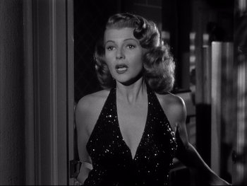 Movie still from “Affair in Trinidad” (1952), directed by Vincent Sherman – A black and white photo of a woman in a black dress; Medium shot, Low angle