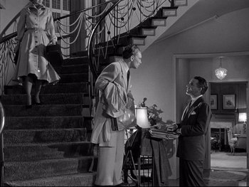 Movie still from “Affair in Trinidad” (1952), directed by Vincent Sherman – A man and a woman standing in front of a staircase; Wide shot, Low angle