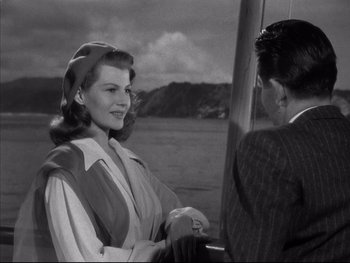 Movie still from “Affair in Trinidad” (1952), directed by Vincent Sherman – A man and a woman sitting on a boat in the water; Medium shot, Over the shoulder angle