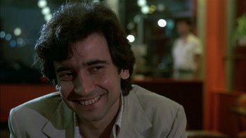 Movie still from “After Hours” (1985), directed by Martin Scorsese – A person sitting at a table; Close Up shot, Low angle