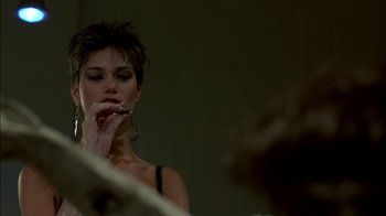 Movie still from “After Hours” (1985), directed by Martin Scorsese – A woman with short brown hair is smoking a cigarette; Close Up shot, Over the shoulder angle