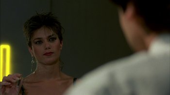 Movie still from “After Hours” (1985), directed by Martin Scorsese – A woman looking into a mirror while standing next to a man; Close Up shot, Over the shoulder angle