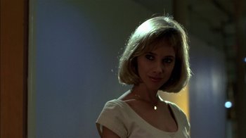 Movie still from “After Hours” (1985), directed by Martin Scorsese – A woman in a white shirt is posing for a picture; Close Up shot, Low angle