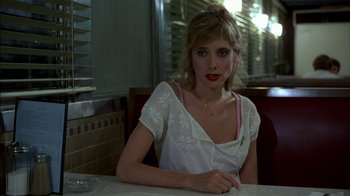 Movie still from “After Hours” (1985), directed by Martin Scorsese – A beautiful young lady sitting at a table in a restaurant; Close Up shot, Over the shoulder angle