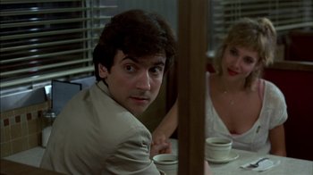 Movie still from “After Hours” (1985), directed by Martin Scorsese – A man and a woman sitting in front of a table; Close Up shot, Over the shoulder angle