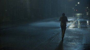 Movie still from “After Hours” (1985), directed by Martin Scorsese – A man walking down a street in the rain; Extreme Wide shot, High angle