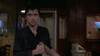 Movie still from “After Hours” (1985), directed by Martin Scorsese – A man in a black shirt holding a towel; Close Up shot, Low angle