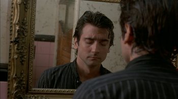 Movie still from “After Hours” (1985), directed by Martin Scorsese – A man looking at his reflection in a mirror; Close Up shot, Over the shoulder angle