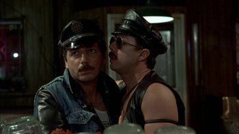 Movie still from “After Hours” (1985), directed by Martin Scorsese – A couple of men wearing leather hats and glasses; Close Up shot, Over the shoulder angle