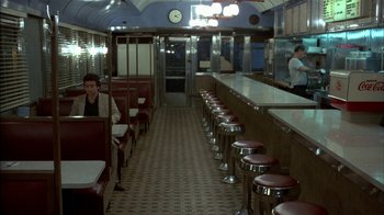 Movie still from “After Hours” (1985), directed by Martin Scorsese – A restaurant with a lot of seats and stools; Wide shot, High angle