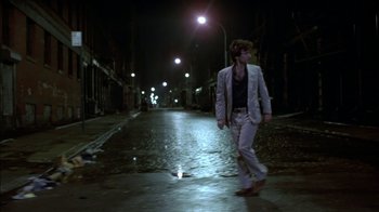 Movie still from “After Hours” (1985), directed by Martin Scorsese – A man walking down a street at night; Wide shot, Low angle