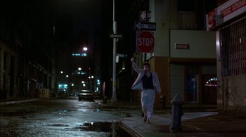 Movie still from “After Hours” (1985), directed by Martin Scorsese – A woman walking down a street at night; Wide shot, Low angle
