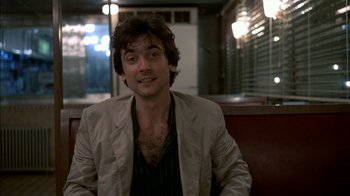 Movie still from “After Hours” (1985), directed by Martin Scorsese – A man sitting on a bench in a restaurant; Close Up shot, Over the shoulder angle