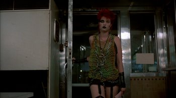 Movie still from “After Hours” (1985), directed by Martin Scorsese – A woman with red hair is standing in front of a door; Medium shot, Low angle