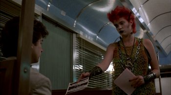 Movie still from “After Hours” (1985), directed by Martin Scorsese – A man with red hair is handing something to another man; Medium shot, Over the shoulder angle