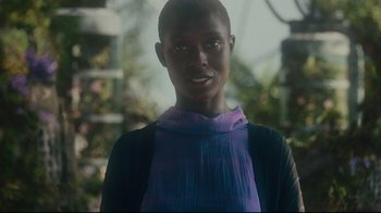 Movie still from “After Yang” (2021), directed by Kogonada – A young woman wearing a blue and purple scarf; Close Up shot, Over the shoulder angle