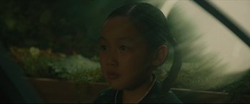 Movie still from “After Yang” (2021), directed by Kogonada – A young asian girl is looking into the distance; Close Up shot, High angle