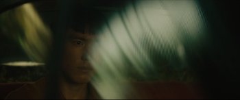 Movie still from “After Yang” (2021), directed by Kogonada – A man is looking out of a window at the camera; Close Up shot, Over the shoulder angle
