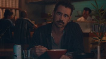 Movie still from “After Yang” (2021), directed by Kogonada – A man sitting at a table with a bowl of food; Close Up shot, Over the shoulder angle
