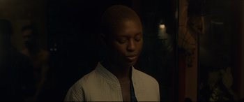 Movie still from “After Yang” (2021), directed by Kogonada – A woman with a shaved head is looking down; Close Up shot, High angle