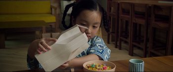Movie still from “After Yang” (2021), directed by Kogonada – A little girl sitting at a table with a bowl of cereal; Close Up shot, High angle