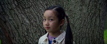 Movie still from “After Yang” (2021), directed by Kogonada – A little girl standing next to a tree; Close Up shot, High angle