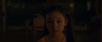 Movie still from “After Yang” (2021), directed by Kogonada – A little girl with long black hair is looking at the camera; Close Up shot, Over the shoulder angle