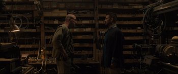 Movie still from “After Yang” (2021), directed by Kogonada – Two men are standing in a room talking to each other; Medium shot, Low angle