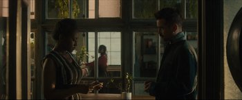 Movie still from “After Yang” (2021), directed by Kogonada – A man and a woman standing in front of a window; Medium shot, Over the shoulder angle