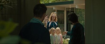 Movie still from “After Yang” (2021), directed by Kogonada – A group of people standing next to each other in front of a building; Medium shot, Over the shoulder angle
