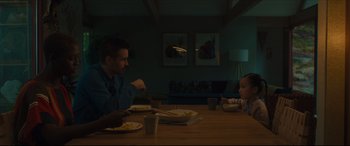 Movie still from “After Yang” (2021), directed by Kogonada – Two people sitting at a table eating food; Medium shot, Over the shoulder angle