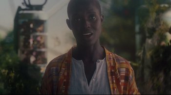 Movie still from “After Yang” (2021), directed by Kogonada – A young man wearing an orange and yellow jacket; Close Up shot, Over the shoulder angle