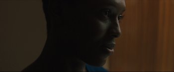 Movie still from “After Yang” (2021), directed by Kogonada – A person's face in the dark; Close Up shot, Over the shoulder angle