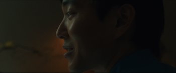 Movie still from “After Yang” (2021), directed by Kogonada – A man's face in the dark; Extreme Close Up shot, Over the shoulder angle