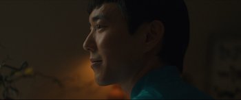 Movie still from “After Yang” (2021), directed by Kogonada – A man's face in the dark; Close Up shot, Low angle