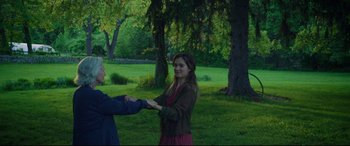 Movie still from “After Yang” (2021), directed by Kogonada – A man and a woman shaking hands in a park; Medium shot, Over the shoulder angle