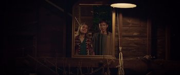 Movie still from “After Yang” (2021), directed by Kogonada – A man and a woman standing in front of a mirror; Medium shot, Low angle