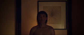 Movie still from “After Yang” (2021), directed by Kogonada – A man standing in front of a painting; Close Up shot, Low angle