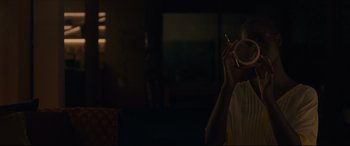 Movie still from “After Yang” (2021), directed by Kogonada – A person is holding a cigarette and a drink; Close Up shot, Over the shoulder angle