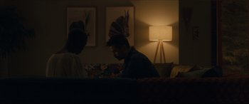 Movie still from “After Yang” (2021), directed by Kogonada – Two men sitting in a living room next to a lamp; Medium shot, Over the shoulder angle