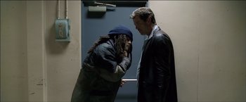 Movie still from “After the Sunset” (2004), directed by Brett Ratner – A man and a woman standing next to each other in front of a door; Medium shot, Low angle