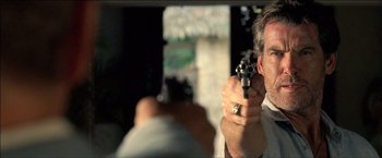 Movie still from “After the Sunset” (2004), directed by Brett Ratner – A man holding a gun pointed to the ground; Close Up shot, Over the shoulder angle