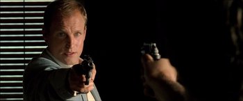 Movie still from “After the Sunset” (2004), directed by Brett Ratner – A man holding a gun in front of a mirror; Close Up shot, Over the shoulder angle