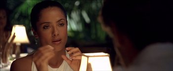 Movie still from “After the Sunset” (2004), directed by Brett Ratner – A woman is looking at her reflection in a mirror; Close Up shot, Over the shoulder angle