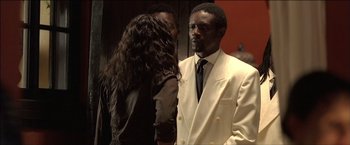Movie still from “After the Sunset” (2004), directed by Brett Ratner – A man and a woman standing next to each other in a room; Medium shot, Over the shoulder angle
