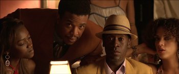 Movie still from “After the Sunset” (2004), directed by Brett Ratner – A couple of men sitting next to each other on top of a bed; Close Up shot, Over the shoulder angle