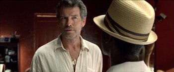 Movie still from “After the Sunset” (2004), directed by Brett Ratner – A person wearing a hat near a person; Close Up shot, Over the shoulder angle