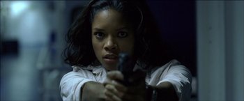 Movie still from “After the Sunset” (2004), directed by Brett Ratner – A woman holding a gun in her hand; Close Up shot, Low angle