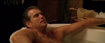 Movie still from “After the Sunset” (2004), directed by Brett Ratner – A shirtless man in a bathtub with a towel on his shoulder; Close Up shot, High angle